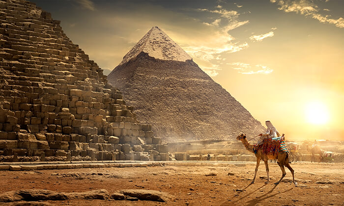 Nomad on camel near pyramids